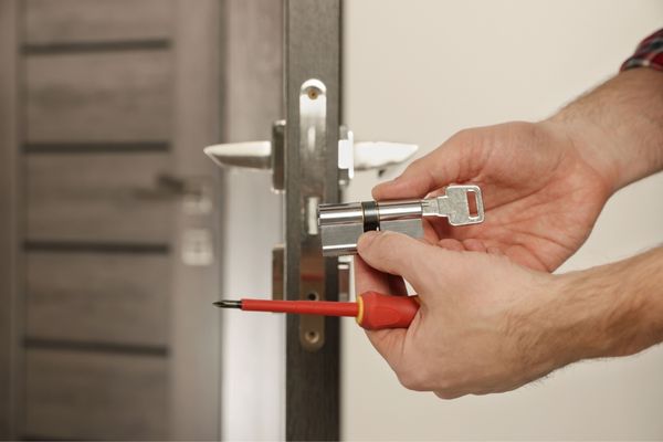 Skilled locksmith repairing damaged door lock
