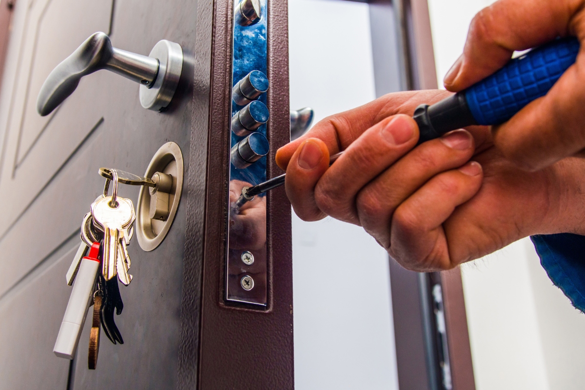 Locksmith installing a door lock.