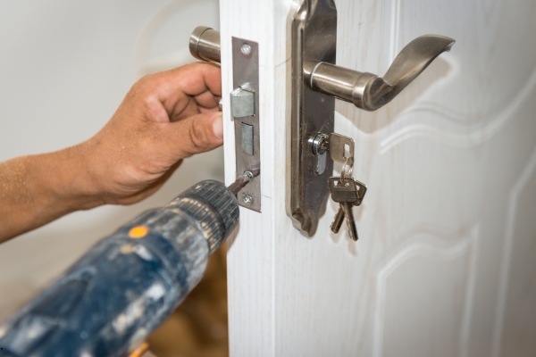 A locksmith working on a door lock
