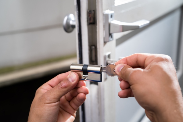Commercial locksmith replacing a door lock.