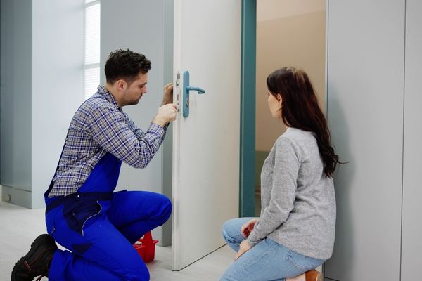 Locksmith repairing door lock for client