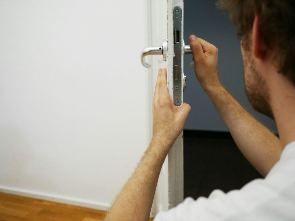 A professional locksmith fixing the door knob