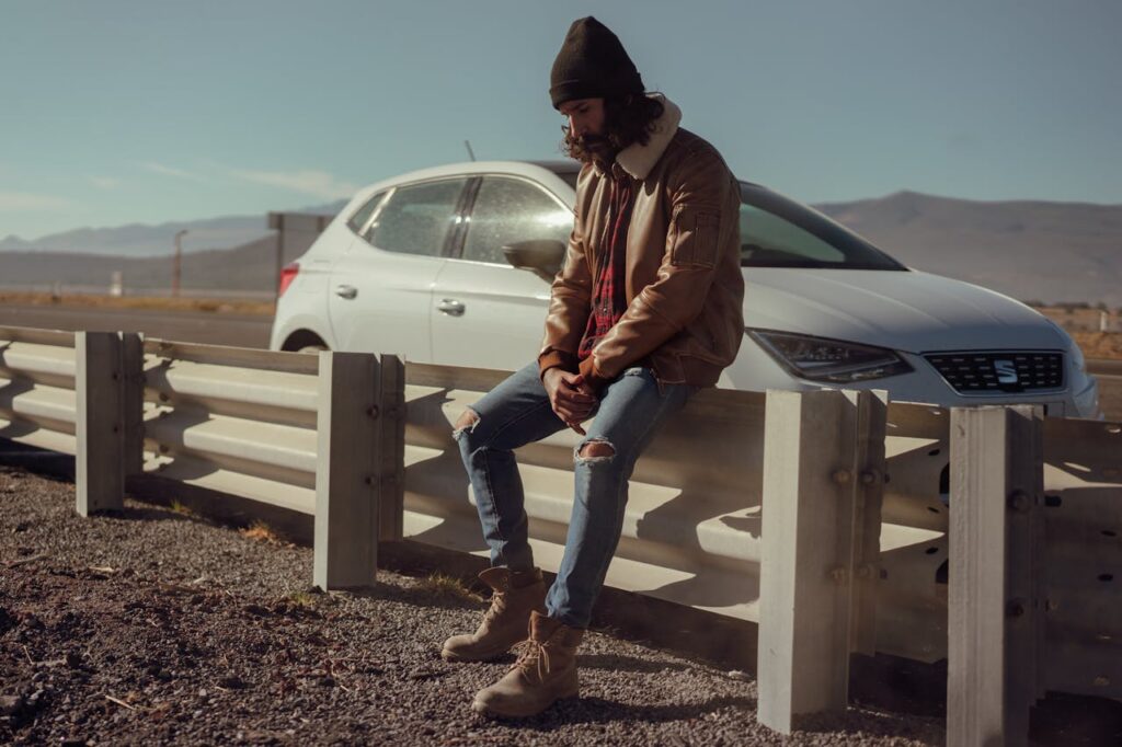 Man sitting on a barricade after being locked out of his keyless car