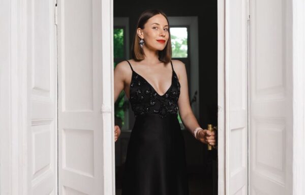 Beautiful woman model dressed black opened the white door